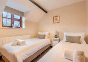 two beds in a small bedroom with a window at Ramblers Rest in Yarpole
