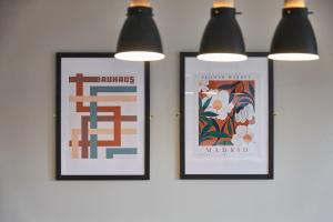 two framed posters hanging on a wall with lights at Ropewalks Retreat III - Sleeping 8 Guests with Parking in Liverpool