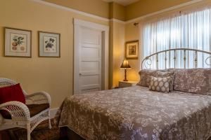ein Schlafzimmer mit einem Bett und einem Stuhl und einem Fenster in der Unterkunft Poe House in Paso Robles