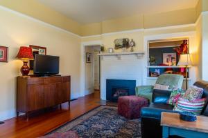 ein Wohnzimmer mit einem TV und einem Kamin in der Unterkunft Poe House in Paso Robles