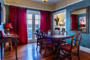 ein Esszimmer mit einem Holztisch und roten Vorhängen in der Unterkunft Poe House in Paso Robles