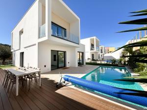 una imagen de una casa con piscina y mesa en Casa do Cruzeiro - BY SCH, en Foz do Arelho