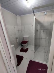 a white bathroom with a shower and a toilet at Casa térrea, aos pés do Cristo! in Encantado +18 photos