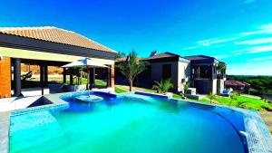 a large swimming pool in front of a house at Tuscany Hill Manor in Hartswater