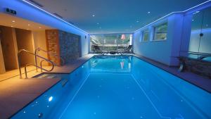 una piscina con iluminación azul en una casa en Hotel Sonnhof, en Innsbruck