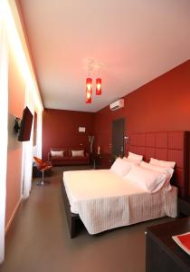 1 dormitorio con 1 cama grande y paredes rojas en Residenza Crescenzio, en Roma