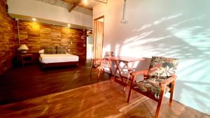 una habitación con una cama, una mesa y sillas en Eco Casa Turistica Necoliving Suites, en Necoclí
