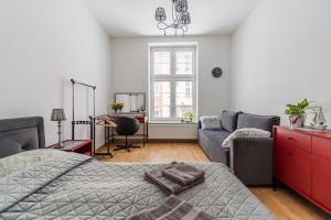 a bedroom with a bed and a couch at Piwna Number 1 in Gdańsk