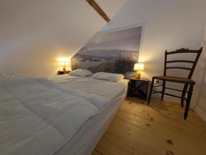 a bedroom with a large bed and a chair at La Fleur de Sel in Les Sables-d'Olonne