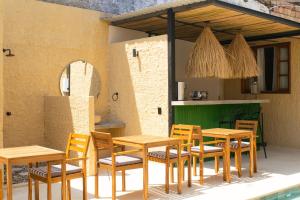 a group of wooden tables and chairs on a patio at Casa Zoé Hotel Boutique in Villeta