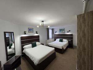 a bedroom with two beds and a mirror at Best Western Ebbw Vale in Ebbw Vale