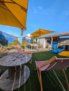 a patio with a table and chairs and an umbrella at La Fleur de Sel in Les Sables-d'Olonne