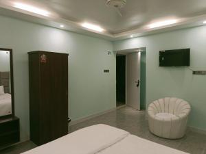 a bedroom with a bed and a chair and a television at Sun Oasis Resort in Cox's Bazar +22 photos