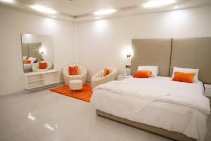 库克斯巴扎Sun Oasis Resort的白色卧室配有一张大床和两把椅子