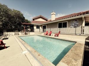 a swimming pool with red chairs and a house at Candlewood Creek in Paso Robles