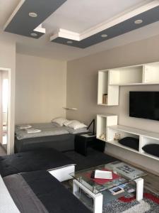 a living room with a bed and a flat screen tv at Home in Zalaegerszeg