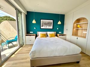 ein Schlafzimmer mit einem Bett und einer blauen Wand in der Unterkunft Appart Matisse face mer parking in Sainte-Maxime