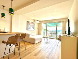 ein Wohnzimmer mit einer Couch und einem Tisch mit Stühlen in der Unterkunft Appart Matisse face mer parking in Sainte-Maxime