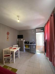 a living room with a table and a kitchen at La casita de la viña in Tinogasta