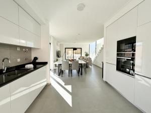 cocina con armarios blancos y comedor en Casa do Cruzeiro - BY SCH, en Foz do Arelho