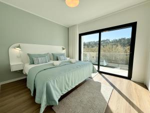 Un dormitorio con una cama grande y una ventana grande en Casa do Cruzeiro - BY SCH, en Foz do Arelho 32 fotos más