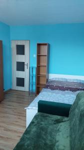 Un dormitorio con una cama grande y una pared azul. en Комната в трёхкомнатной квартире, en Wroclaw