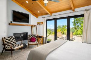 a bedroom with a bed and a flat screen tv at Cocavin Carriage House in Paso Robles