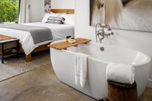 a bathroom with a bed and a bathtub next to a bath tub at Cocavin Carriage House in Paso Robles