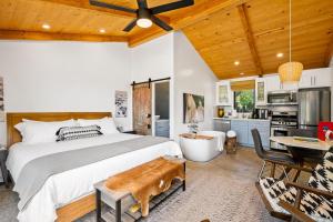 a bedroom with a large bed and a kitchen at Cocavin Carriage House in Paso Robles