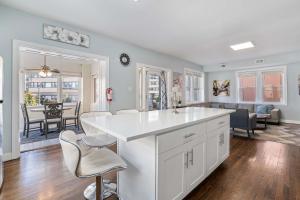una cucina e un soggiorno con bancone e sedie bianchi di Luxe Beach Estate - 4 Bedrooms and 3 Bathrooms ad Atlantic City Altre 35 foto