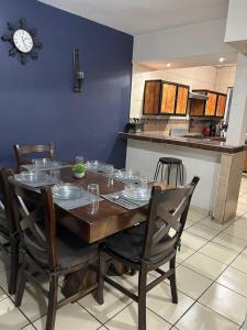 ein Esstisch mit Stühlen und einer Uhr an der Wand in der Unterkunft Rincon Mágico in Ciudad Valles