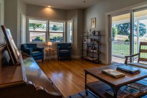 a living room with a piano and a table at Graceful Oaks in Paso Robles
