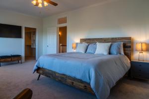 a bedroom with a large bed and a flat screen tv at Graceful Oaks in Paso Robles +51 photos