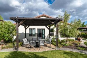 a wooden pergola with chairs and a table in a yard at Cloud 9 in Paso Robles