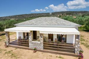 a house with a porch with chairs and a roof at Zara Studios in Astris
