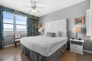 een slaapkamer met een bed, een plafondventilator en een raam bij Marvelous Oceanfront 12th Floor 3BR Retreat at The WyndhamOcean Walk Resort in Daytona Beach +29 foto's