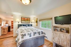 a bedroom with a bed and a flat screen tv at Minnehaha Allenspark Cabin Near Hiking! in Allenspark