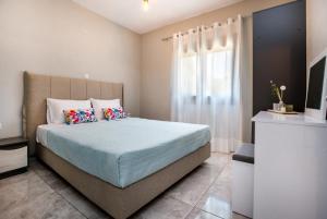 a bedroom with a bed with blue sheets and a window at Zara Studios in Astris