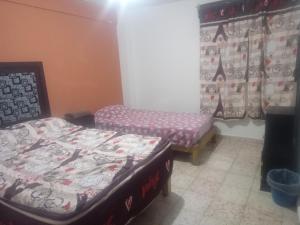 Habitación con 2 camas, banco y cortinas en Departamento para 5 o 7, en Uruapan del Progreso