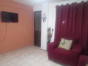 sala de estar con silla roja y TV en Departamento para 5 o 7, en Uruapan del Progreso