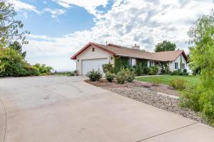 a white house with a driveway at Vista Vine Cottage in San Miguel