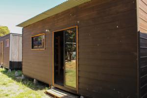 eine Holzhütte mit einer Seitentür in der Unterkunft EXIT Tiny House in Pucón