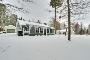 a green house with snow on the ground in a yard at 9 Mi to Snowmobile Trails! Home Near Mullett Lake in Cheboygan