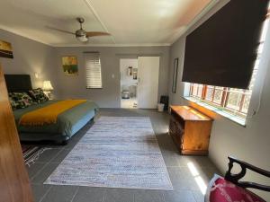 ein Schlafzimmer mit einem Bett und einem Flachbildfernseher in der Unterkunft Charming Garden Cottage in Gqeberha