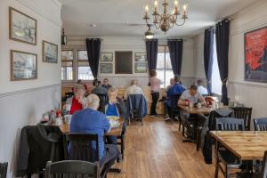 a group of people sitting at tables in a restaurant at Picton Harbour Inn in Picton