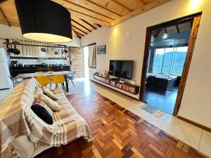 a living room with a couch and a table and a television at Refúgio de Lavras in Ouro Preto