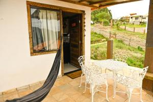 a patio with a table and chairs and a window at Refúgio de Lavras in Ouro Preto