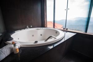 a bath tub in a bathroom with a large window at Refúgio de Lavras in Ouro Preto +27 photos