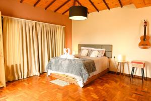 a bedroom with a bed and a guitar in it at Refúgio de Lavras in Ouro Preto