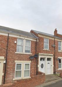ein altes Backsteinhaus mit weißen Türen und Fenstern in der Unterkunft Overhill 3 bedroom flat 5 beds, free parking, ideal for Contractors in Gateshead